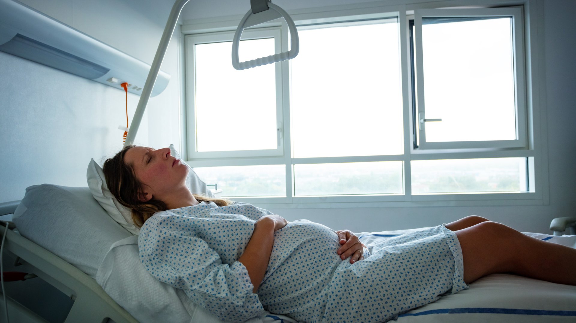 Kobieta w ciazy lezy na lozku szpitalnym