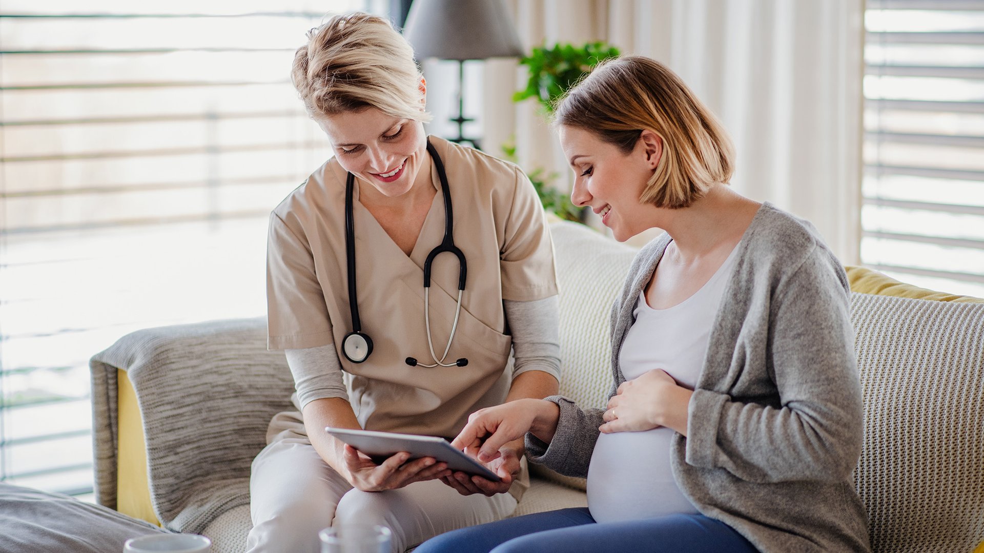 Kobieta w ciazy konsultuje sie z lekarka siedzac na kanapie
