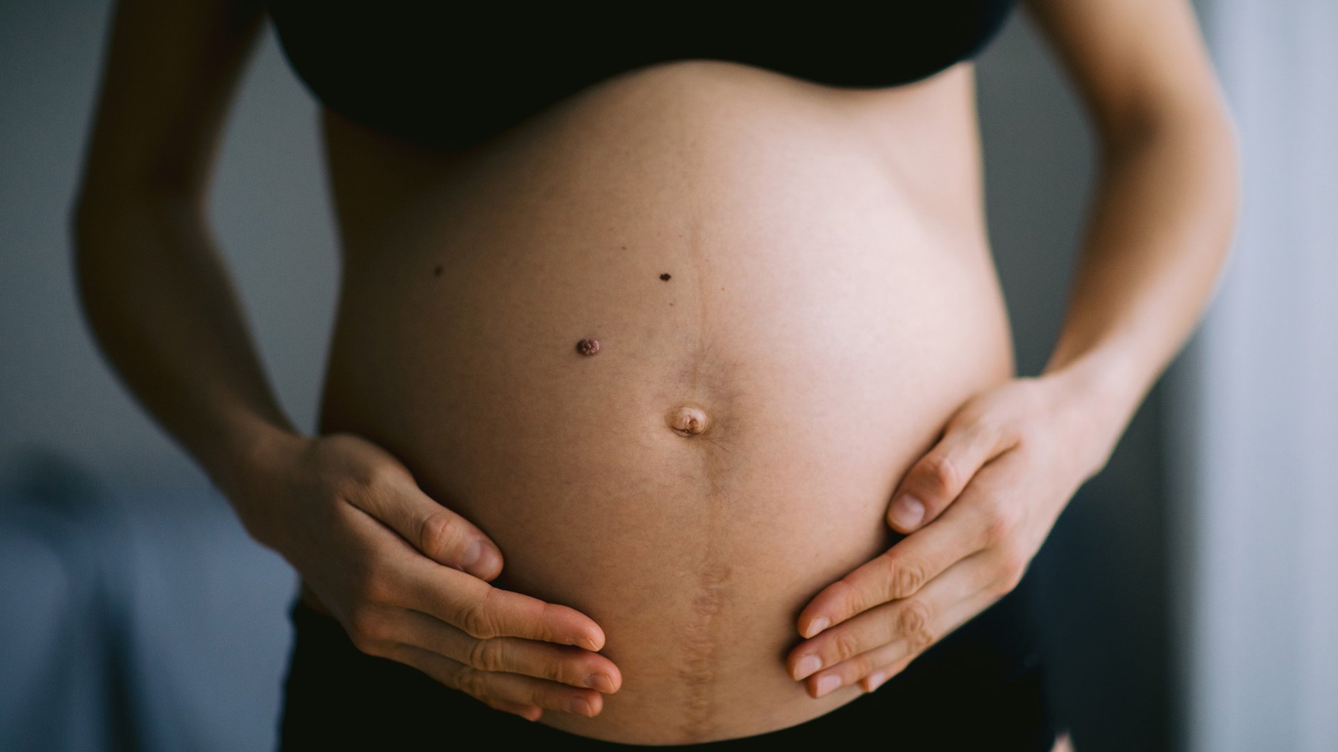 kobieta w czarnej bieliznie trzyma się za cizowy brzuch