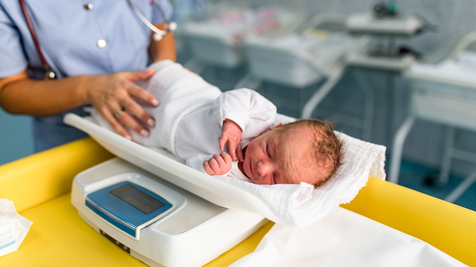 Pielegniarka wazy dziecko na wadze dzieciecej