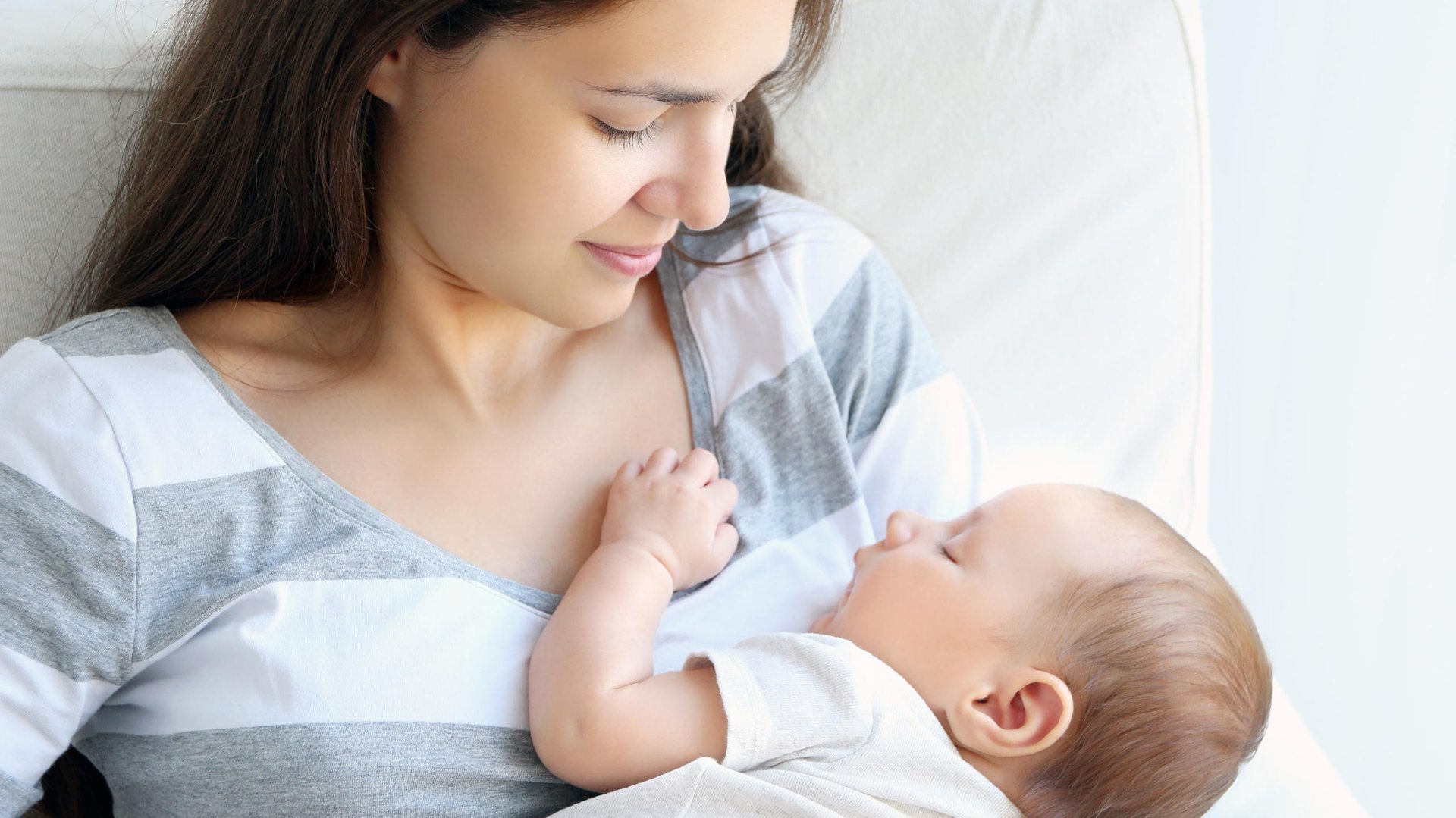 Mama przytula spiace dziecko do piersi