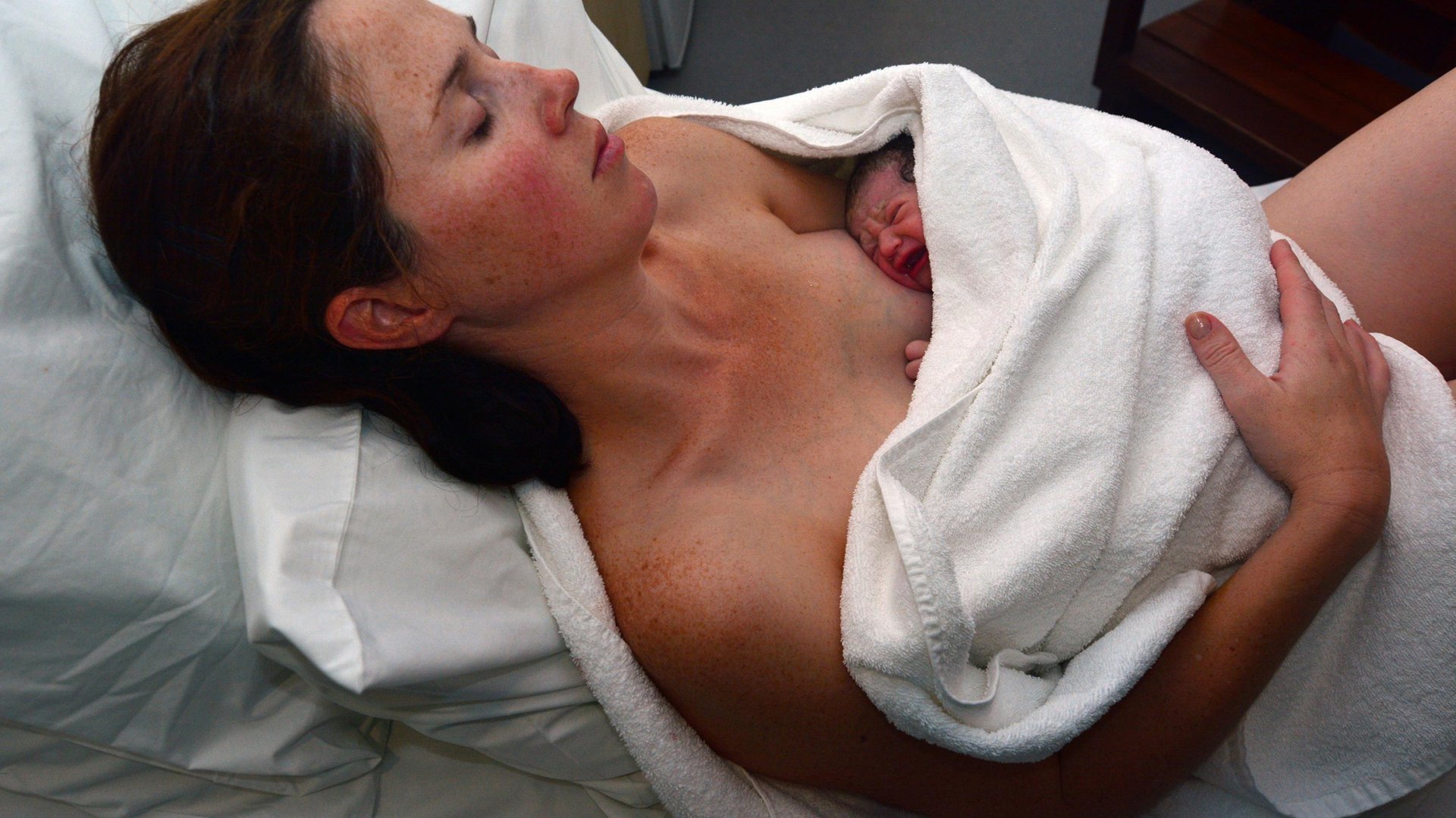 Mama lezy z noworodkiem po porodzie