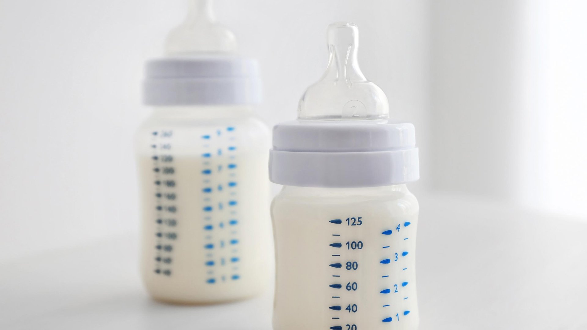 Dzie pelne butelki mleka dla dziecka stoja na stole