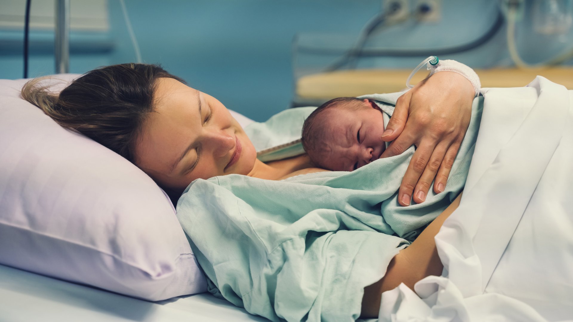 Kobieta trzyma przy piersi nowonarodzone dziecko