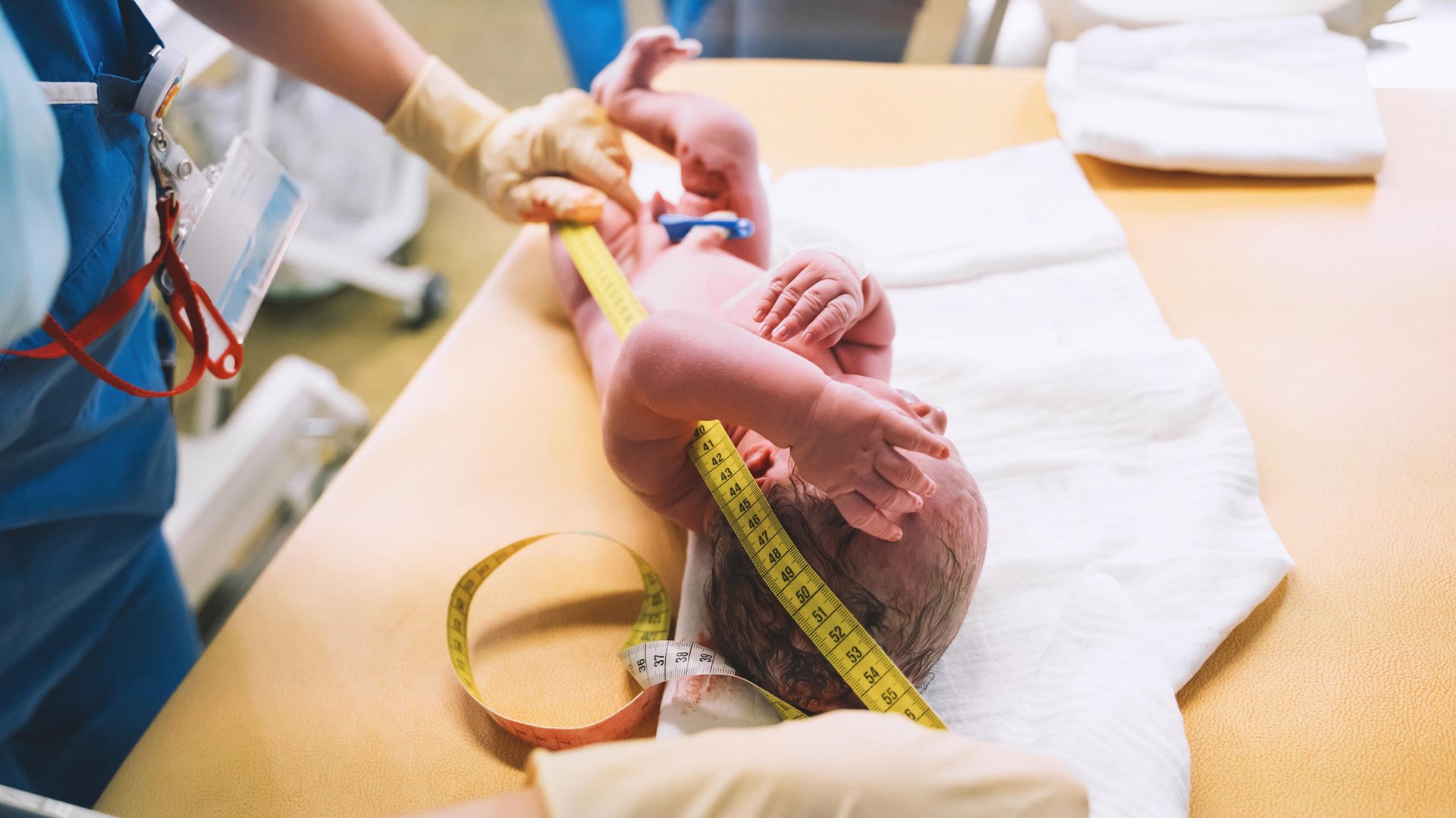 Pielegniarka mierzy miarka noworodka
