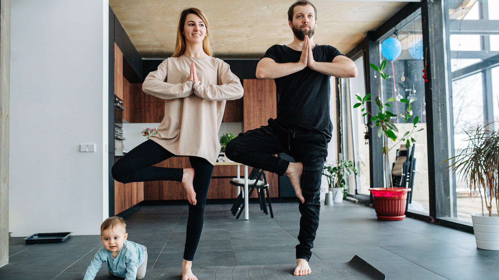 Rodzice i dziecko cwicza joge na macie
