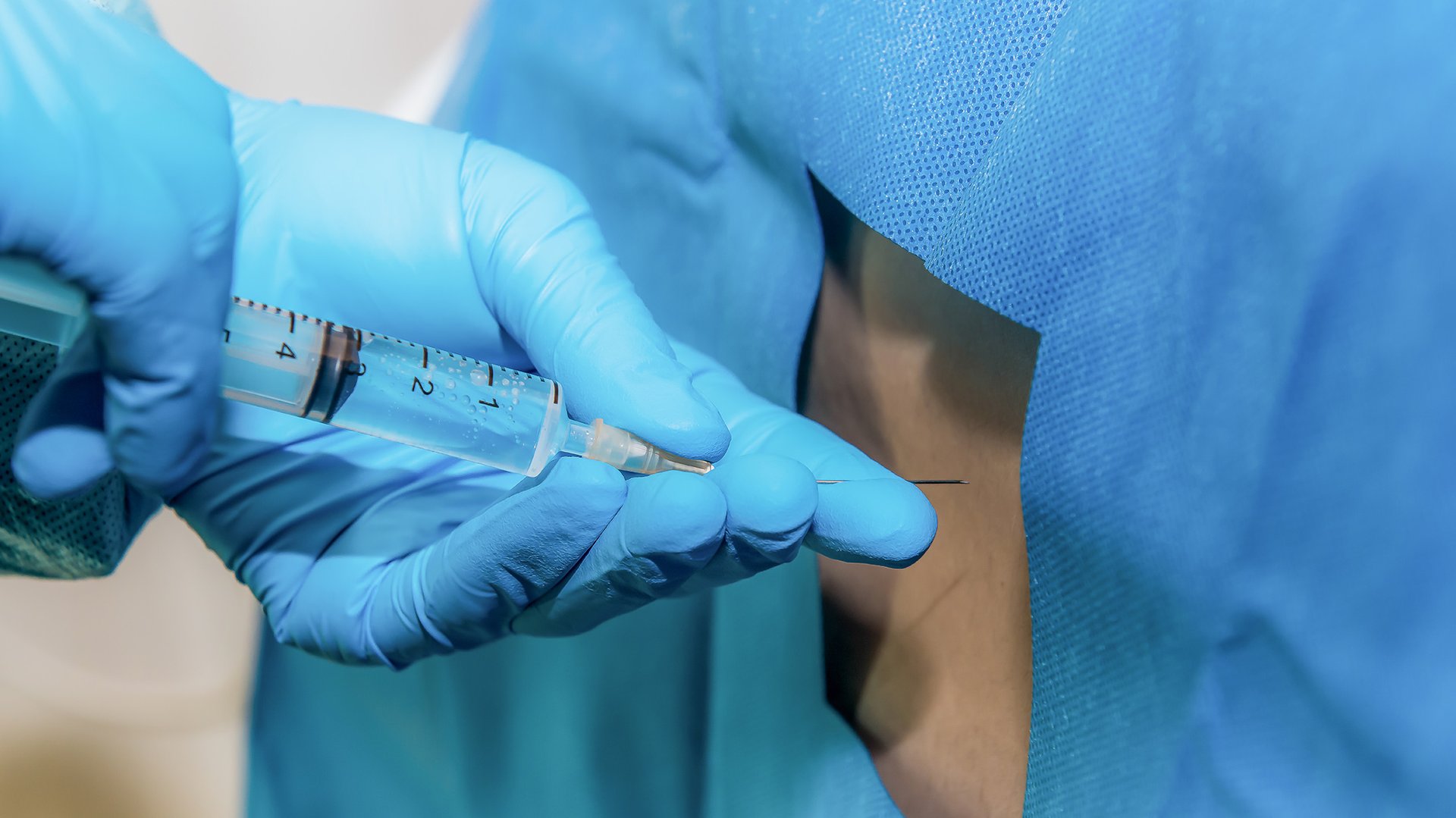 Lakarz wylonuje zastrzyk ze znieczuleniem